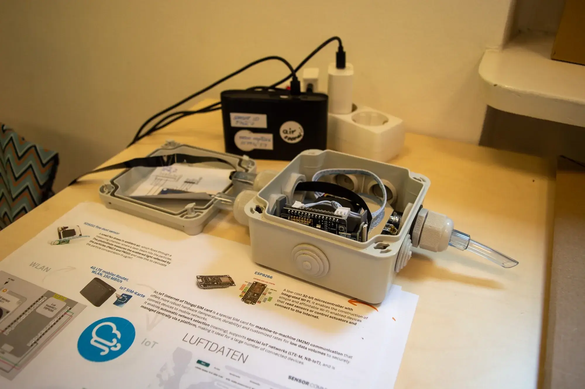 Geöffnete Verteilerdose mit Feinstaubsensor - die Miniaturstadt misst ihre eigene Luftqualität